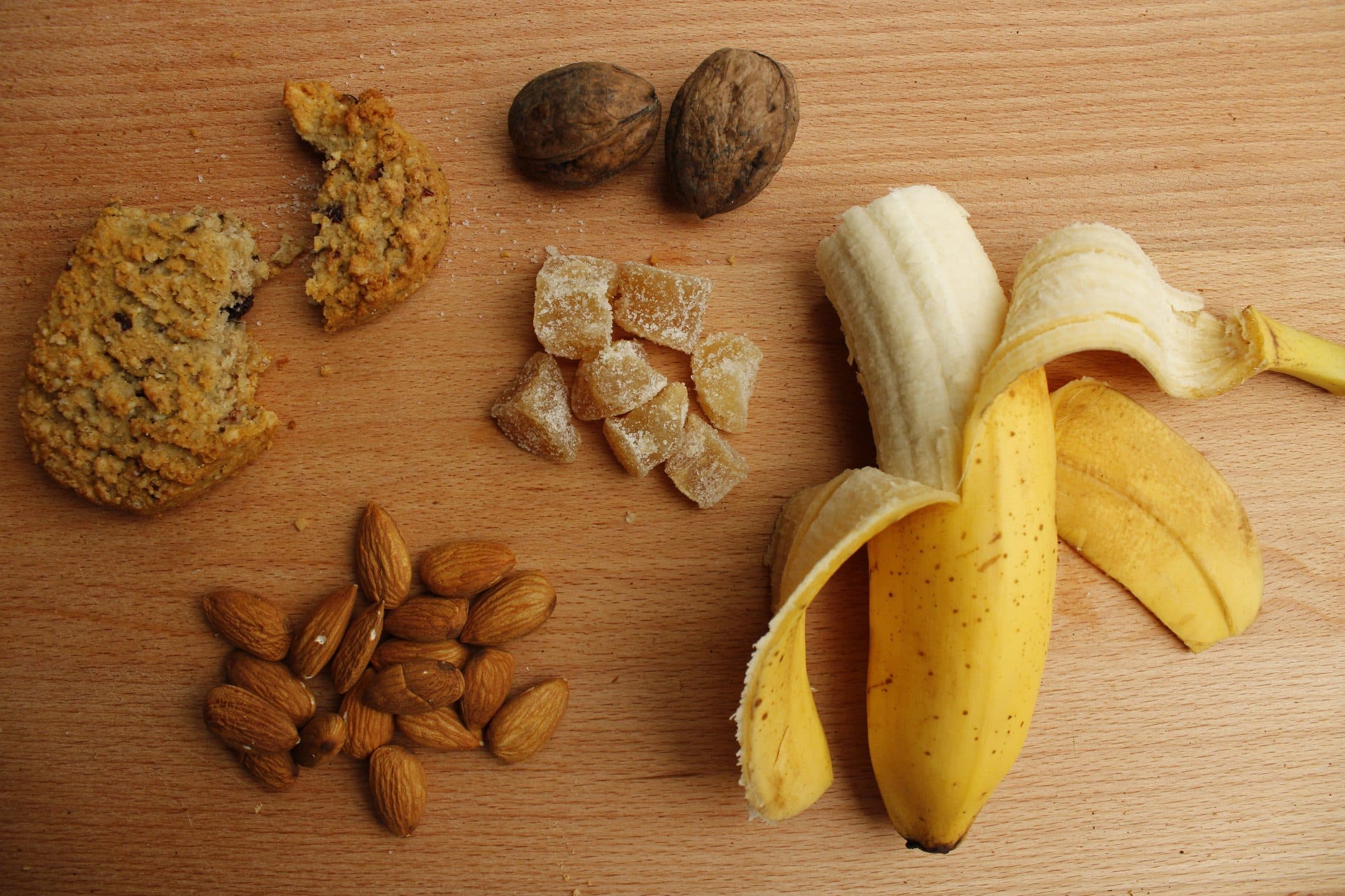 Mixed nuts and dried fruit arranged on a wood surface